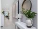 Bright hallway with modern decor, leading to the dining room with a decorative mirror and plant at 8937 Amelia Downs Trl, Kissimmee, FL 34747
