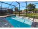 Screened-in pool and hot tub with brick surround and view of the community at 8937 Amelia Downs Trl, Kissimmee, FL 34747
