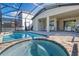 Covered patio with screened-in pool and hot tub, plus outdoor kitchen area at 8937 Amelia Downs Trl, Kissimmee, FL 34747