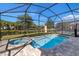 Screened-in pool and hot tub with brick surround and views of the community at 8937 Amelia Downs Trl, Kissimmee, FL 34747