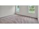 Cozy bedroom with neutral carpet, natural light from two windows, and a serene atmosphere at 14927 Sw 25Th Cir, Ocala, FL 34473
