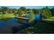 Scenic aerial view of a wooden bridge over a waterway, surrounded by lush green trees and landscaping at 4331 Valencia Dr, Indian Lake Estates, FL 33855