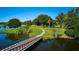 Lush green landscape with a curved sidewalk over a waterway, as well as mature trees and foliage at 4331 Valencia Dr, Indian Lake Estates, FL 33855