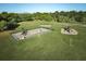 Aerial view of community playground equipment surrounded by lush green grass and trees at 4331 Valencia Dr, Indian Lake Estates, FL 33855