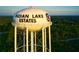 Aerial view of the Indian Lake Estates water tower surrounded by lush green trees, a prominent community landmark at 4331 Valencia Dr, Indian Lake Estates, FL 33855