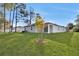 Spacious backyard featuring a well-maintained lawn, young tree, and a charming single-Gathering home with a covered patio at 4711 Sw 136Th Pl, Ocala, FL 34473