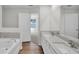 Well-lit bathroom featuring double sinks, quartz countertops, wood-look flooring, and a soaking tub at 4711 Sw 136Th Pl, Ocala, FL 34473