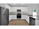 Contemporary kitchen boasts stainless appliances, stone counters, and shaker cabinets at 4711 Sw 136Th Pl, Ocala, FL 34473