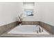 Elegant bathroom featuring a soaking tub and a garden view window at 2901 Protagonist St, Kissimmee, FL 34746