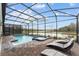 Screened-in pool and spa area with brick patio and lounge chairs offering serene water views in this community at 2901 Protagonist St, Kissimmee, FL 34746