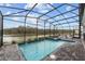 Screened-in pool area with hot tub overlooking tranquil lake views and comfortable lounge chairs at 2901 Protagonist St, Kissimmee, FL 34746