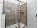 Modern shower with glass door, gray tile, built-in niche, and rainfall shower head at 2901 Protagonist St, Kissimmee, FL 34746