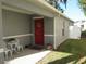 Inviting front entry with red door, white chairs, and landscaping at 2608 Whitewood Road, Mulberry, FL 33860