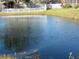 Serene pond view, featuring a calm waterscape and houses in the distance at 2608 Whitewood Road, Mulberry, FL 33860