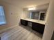 Spacious bathroom featuring double vanity, large mirror, modern lighting, and gray tile flooring at 2659 Park Ridge St, Apopka, FL 32712