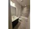Well-lit bathroom featuring a vanity with a dark brown cabinet and a tub-shower combination with horizontally laid tiling at 2659 Park Ridge St, Apopka, FL 32712