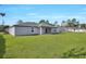 Well-maintained backyard featuring a lush lawn and a covered patio, perfect for outdoor living at 2722 Sw 151St Pl, Ocala, FL 34473