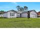 View of the charming gray home, showcasing its well-maintained lawn and inviting facade at 2722 Sw 151St Pl, Ocala, FL 34473