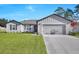 Charming single-story home with a well-manicured lawn, gray siding, and an attached two-car garage at 2722 Sw 151St Pl, Ocala, FL 34473