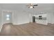 Open-concept living room with wood flooring flowing into a modern kitchen with white cabinets at 2722 Sw 151St Pl, Ocala, FL 34473