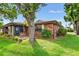 Brick home with a screened patio, lush landscaping, and a large tree at 565 Lake Mystic Ln, Lakeland, FL 33813