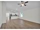 Open-concept living room featuring modern wood floors, ceiling fan, and a seamless transition to the kitchen area at 418 Marion Oaks Ln, Ocala, FL 34473
