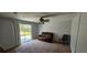 A living room with sliding glass doors to the backyard and a dark brown leather couch at 1814 Lowry Ave, Lakeland, FL 33801