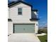 Two-story home with a sage green garage door and a clean white concrete driveway at 902 Poppy Ln, Dundee, FL 33838