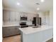 Modern kitchen with island, stainless steel appliances, and ample cabinetry at 2036 Marigold Aly, Winter Haven, FL 33884