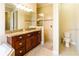 Well-lit bathroom featuring a granite countertop, wood cabinets, a separate shower, and a toilet at 8339 Bridgeport Bay Cir, Mount Dora, FL 32757