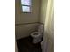 Small powder room with open toilet, wainscotting, and wood look flooring at 1219 Dixie Dr, Auburndale, FL 33823