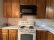 Kitchen featuring light cabinets and appliances, and tile backsplash at 1219 Dixie Dr, Auburndale, FL 33823