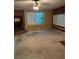 Empty living room featuring a brick fireplace, natural lighting and outdated carpet at 1219 Dixie Dr, Auburndale, FL 33823