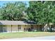 Charming single-story home with tan siding, a covered porch, and a well-maintained front yard at 1335 Dean St, Mulberry, FL 33860