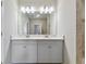 Double vanity bathroom with large mirror and gray tile flooring at 4885 Foxglove Cir, Lakeland, FL 33811