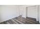 Bright bedroom featuring luxury vinyl plank flooring, white walls, and a closet at 2700 Laguna Dr, Indian Lake Estates, FL 33855