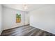 Bright bedroom featuring hard surface floors, closet and a large window at 2700 Laguna Dr, Indian Lake Estates, FL 33855