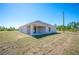 Exterior of the home showing back patio and well-manicured lawn at 2700 Laguna Dr, Indian Lake Estates, FL 33855