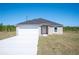 New single-Gathering home with a gray roof, white garage, and long concrete driveway at 2700 Laguna Dr, Indian Lake Estates, FL 33855