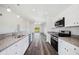 Open-concept kitchen with stainless steel appliances flows into a spacious living area with sliding glass doors at 2700 Laguna Dr, Indian Lake Estates, FL 33855