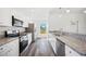 Bright kitchen features stainless steel appliances, granite countertops, and modern white cabinetry at 2700 Laguna Dr, Indian Lake Estates, FL 33855