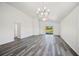 Living room featuring vinyl floors with bright white walls, ceiling fan, and sliding glass door at 2700 Laguna Dr, Indian Lake Estates, FL 33855