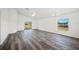 Living room featuring vinyl floors with bright white walls, ceiling fan, and sliding glass door at 2700 Laguna Dr, Indian Lake Estates, FL 33855