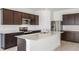 Modern kitchen with dark brown cabinets, stainless steel appliances, and an island at 4390 Sw 84Th Street Rd, Ocala, FL 34476