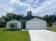Alluring single-story home featuring a lush green lawn, a practical two-car garage, and pleasing curb appeal at 4270 Sw 143Rd Lane Rd, Ocala, FL 34473