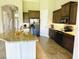 Bright kitchen featuring granite counters, stainless appliances, and view to the entry way at 7771 Lake James Blvd, Lakeland, FL 33810