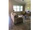 Comfortable living room features tile floors, large bright windows, and neutral decor at 7771 Lake James Blvd, Lakeland, FL 33810