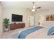 Spacious main bedroom with a large TV, ensuite bathroom access, and ceiling fan at 31817 Sunpark Cir, Leesburg, FL 34748