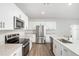 Modern kitchen with white cabinets and stainless steel appliances at 2056 Marigold Aly, Winter Haven, FL 33884