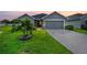 Gray house with a two-car garage and lush green lawn in the front at 6388 Gardner Dr, Lakeland, FL 33813